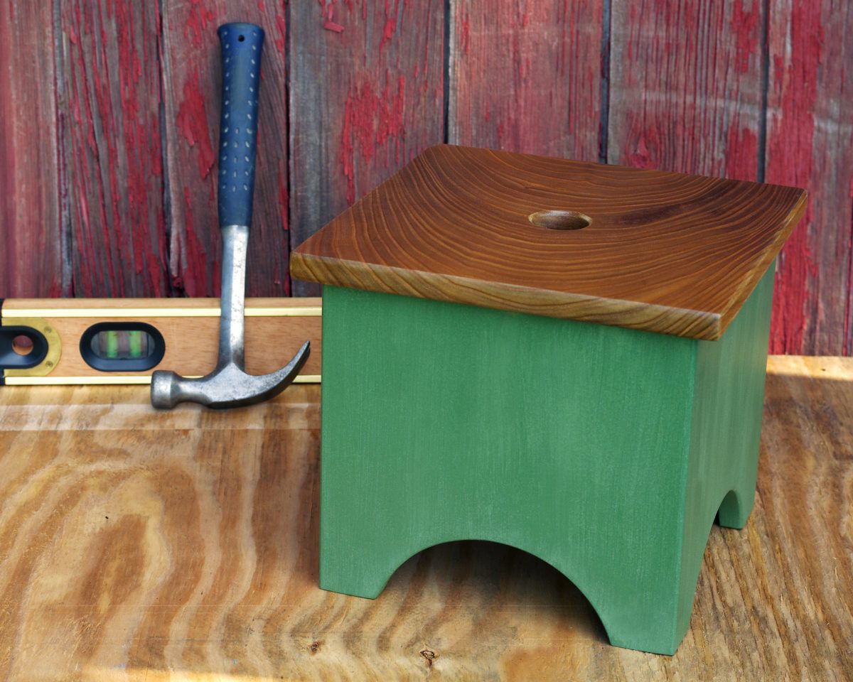 Green step stool with hammer behind it