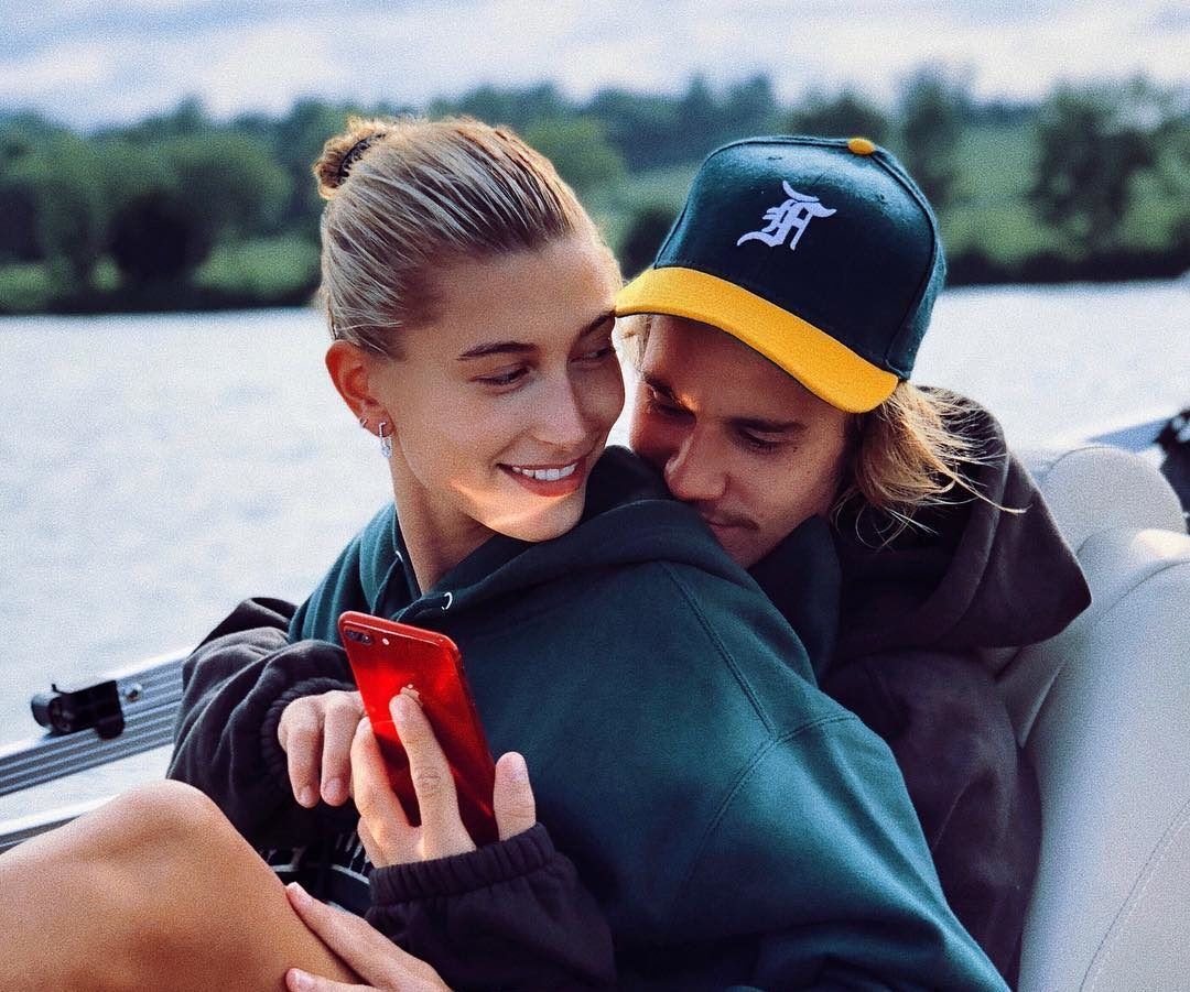 Hailey Baldwin and Justin Bieber cuddling on a boat