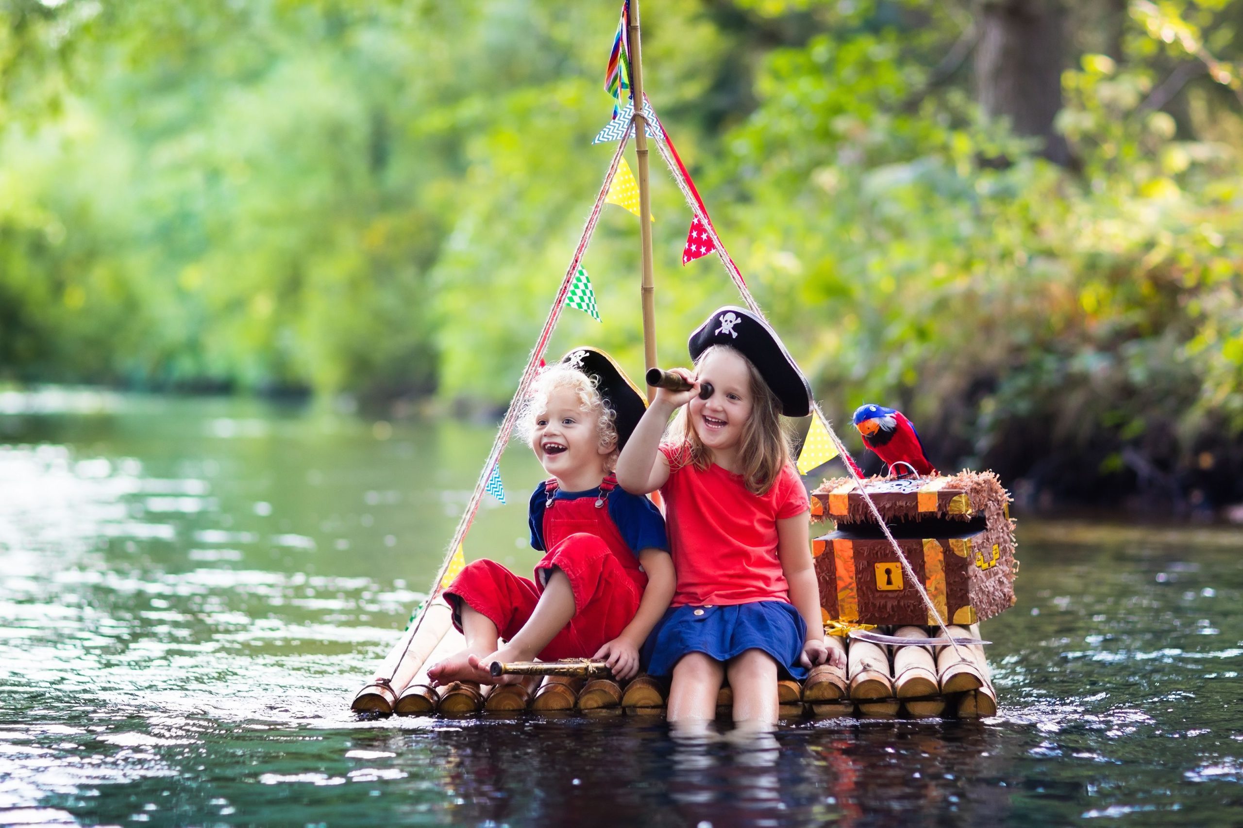 Two young children dressed as pirates on a little raft