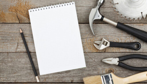 Set of tools on cork panel background with notepad