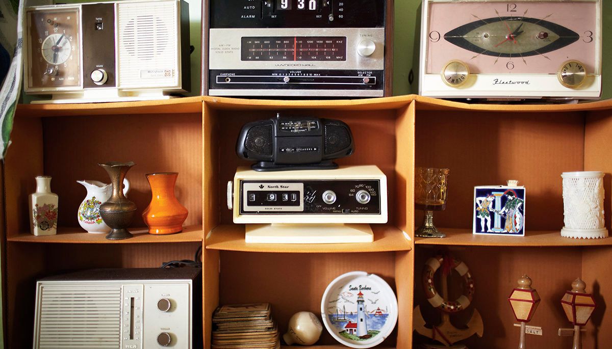 plastic flip clock radios and old sound equipment on a shelf