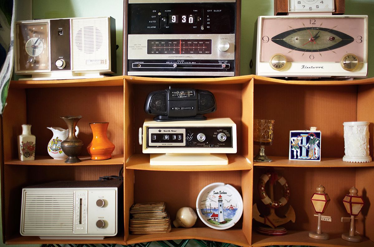 plastic flip clock radios and old sound equipment on a shelf