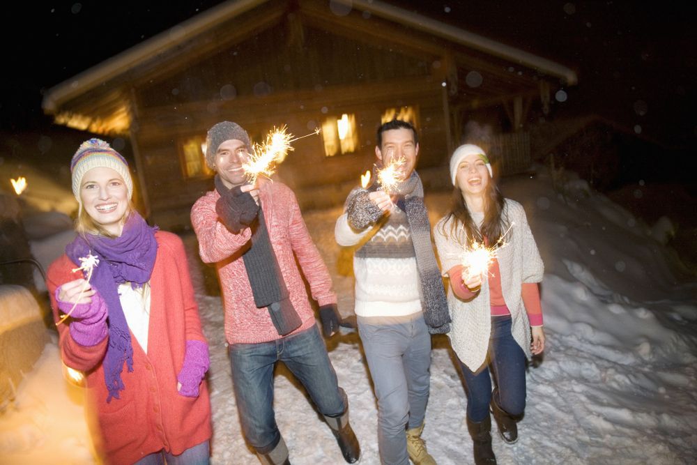 friends with sparklers at a log cabin