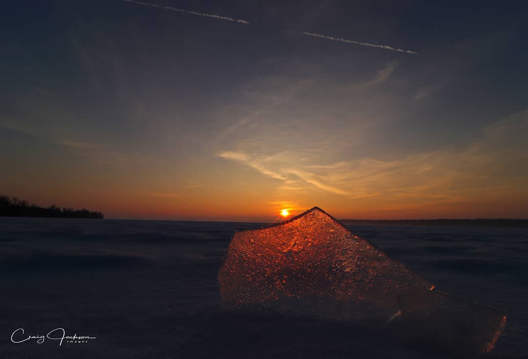 piece of ice in front of sunset on winter lake