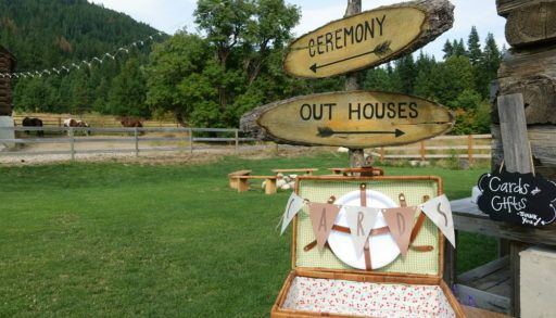 signs at an outdoor wedding point to outhouse toilet