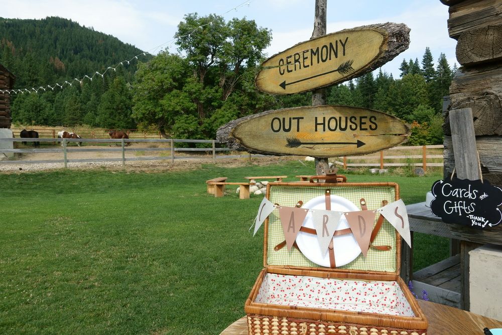 signs at an outdoor wedding point to outhouse toilet