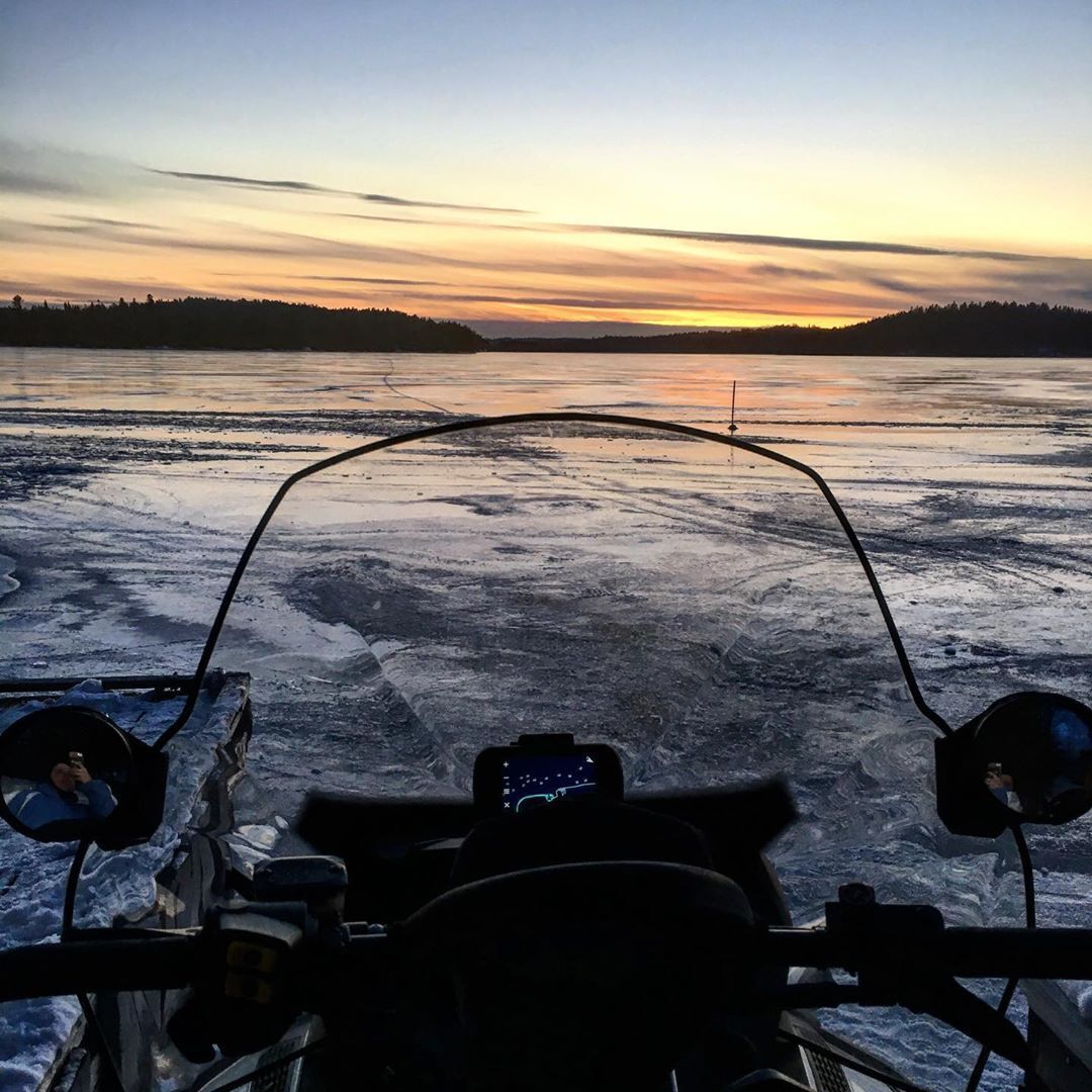 snowmobile windshield in front of frozen lake in winter
