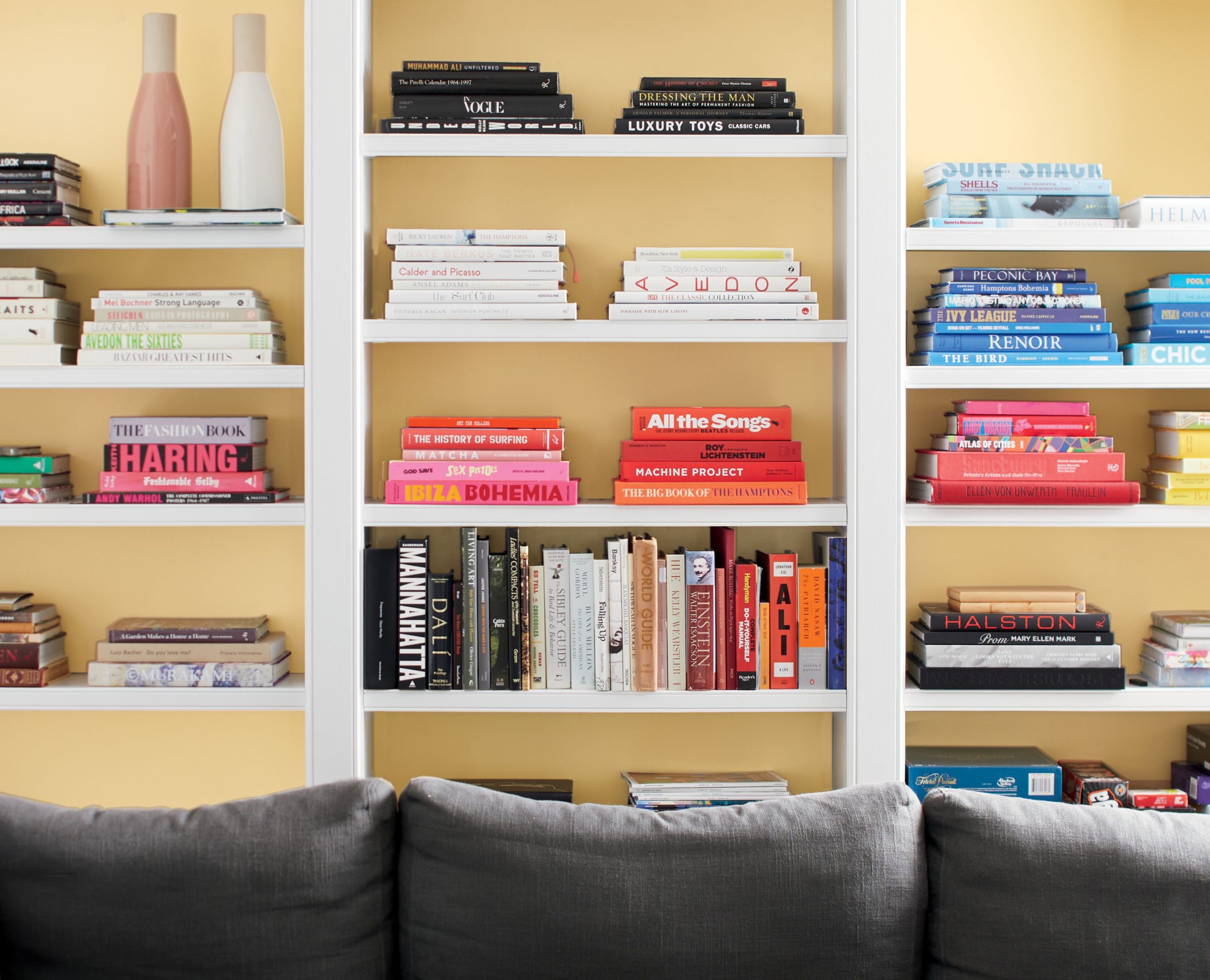 A bookshelf with the inside of the shelves painted yellow