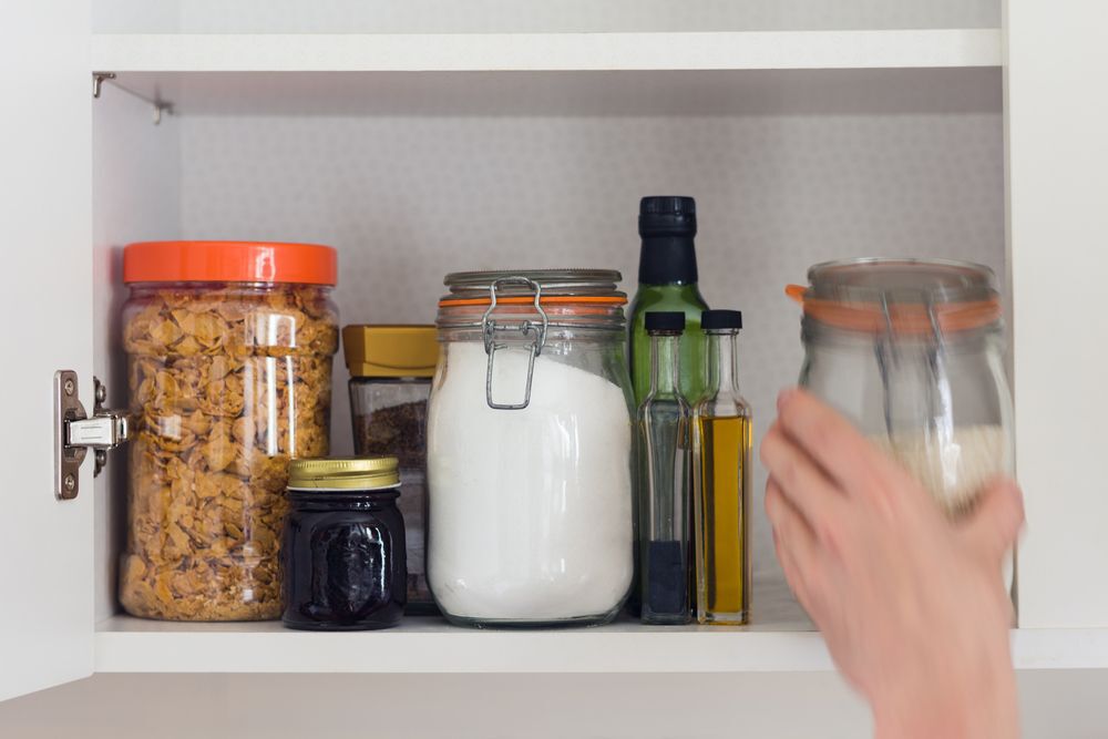 person reaching into the pantry for basic ingredients