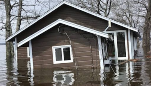A cottage is half submerged in flood waters