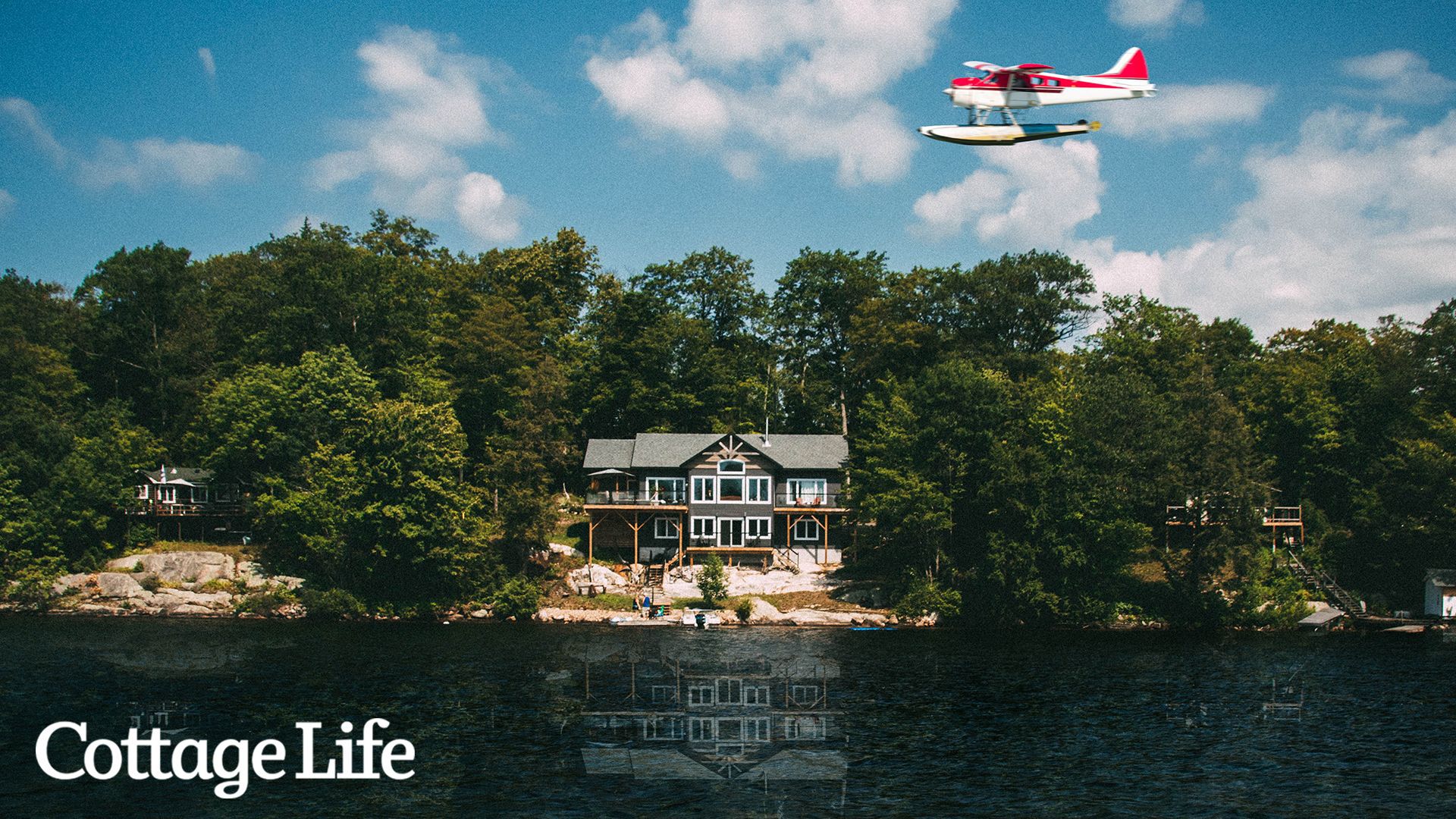 A plane flies by a cottage