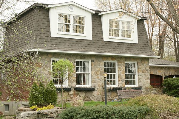 Stone executive cottage with mansard roof.