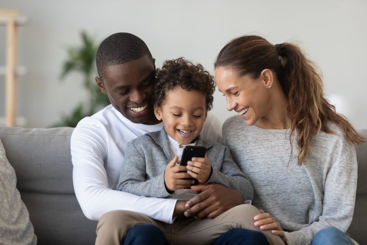 Family looking at phone on couch