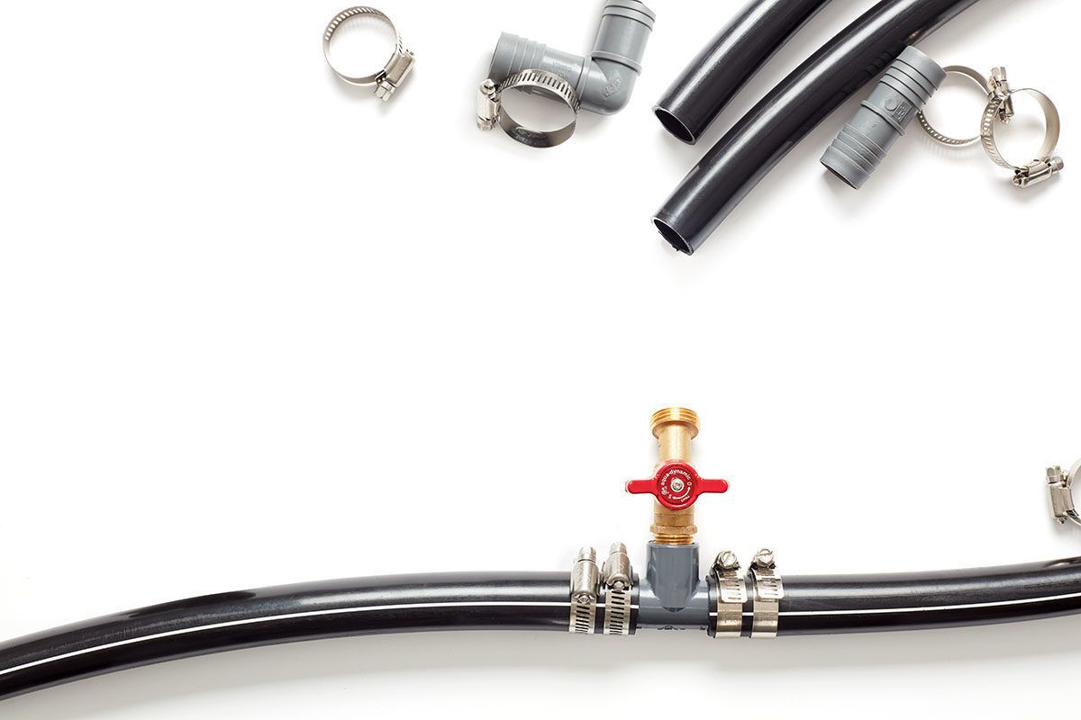 black poly pipe water system connected, pieces of black pipe and clamps on white background