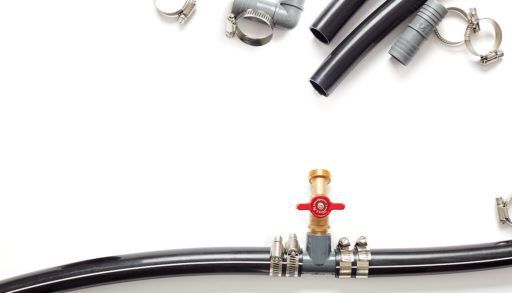 black poly pipe water system connected, pieces of black pipe and clamps on white background