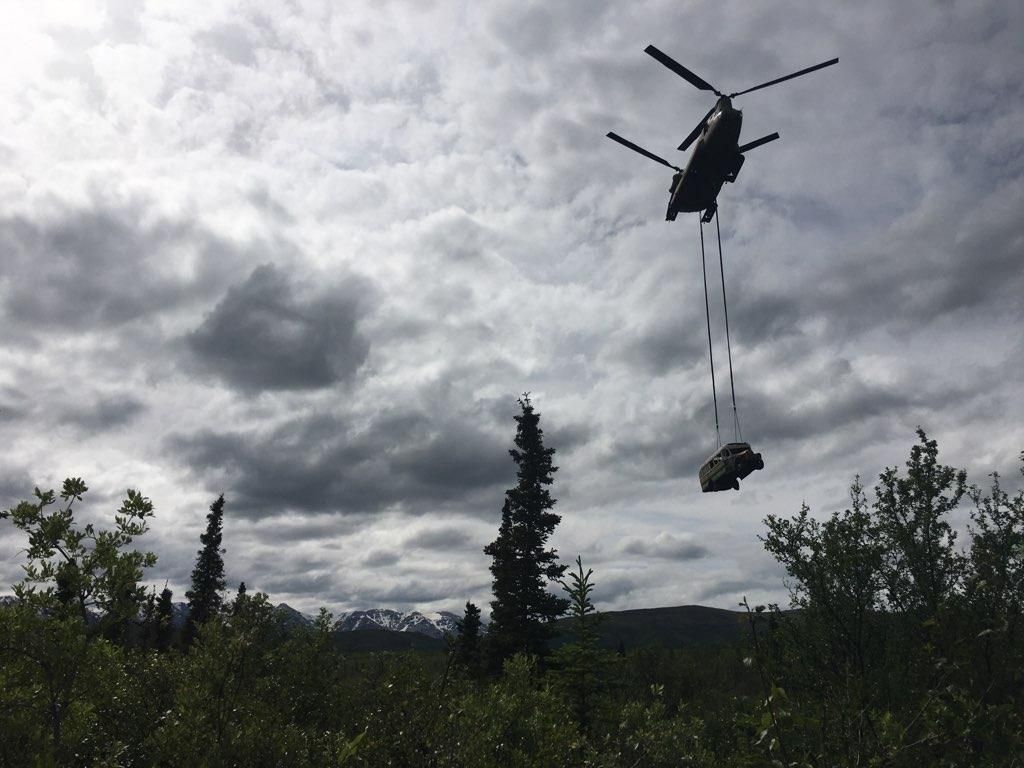 Silhouette of helicopter lifting bus