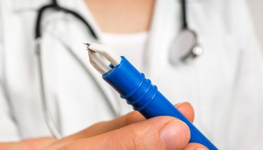 Female doctor is holding tweezers with a tick. Encephalitis, borreliosis and lyme disease