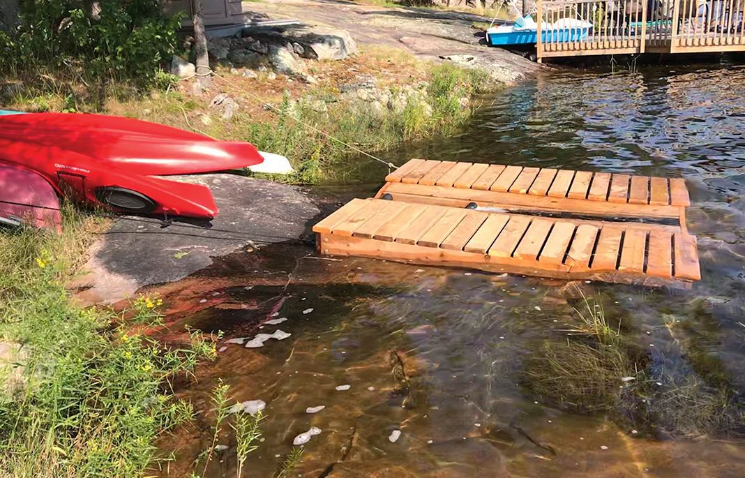 diy project sitting on rocky lake shore, canoe and kayak launch pad