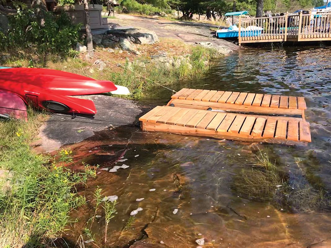 diy project sitting on rocky lake shore, canoe and kayak launch pad
