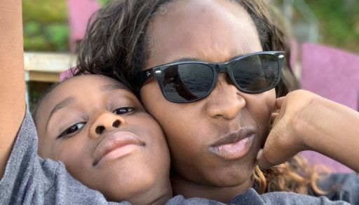 tanya hayles and her son sitting on a dock at a cottage