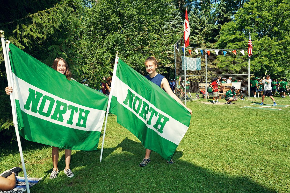 Two girls hold up North flags at the annual Bruce Beach baseball game