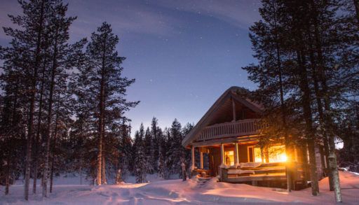 a snow load on a snowy cabin in the woods