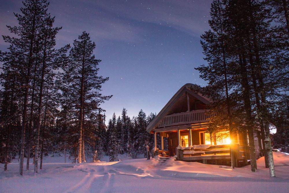 a snow load on a snowy cabin in the woods
