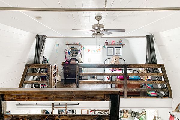 wide shot of an open loft style second floor with a bedroom