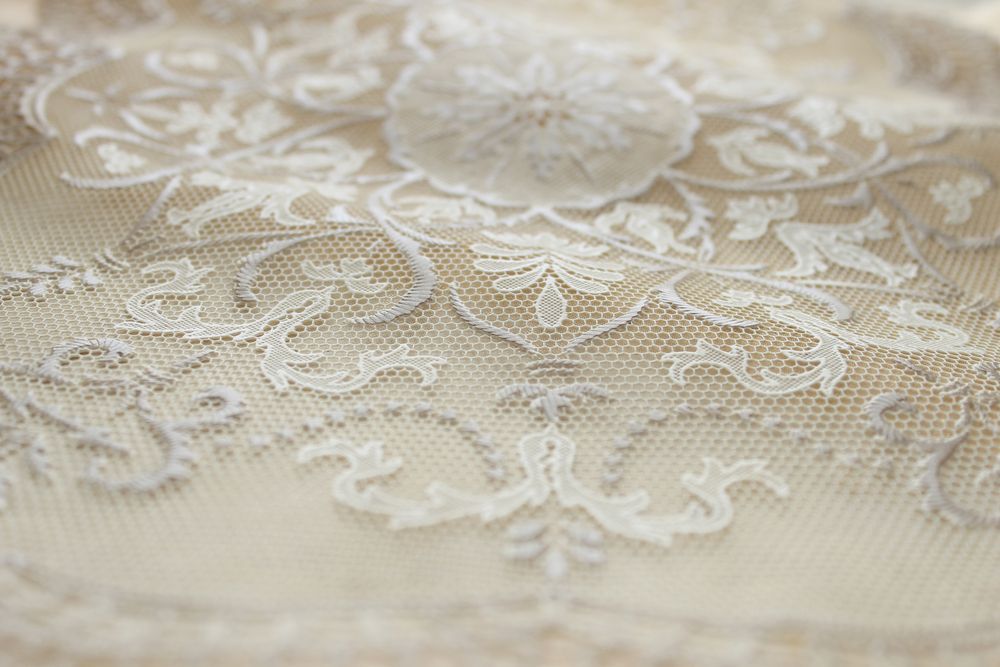 A close-up of an off-white lace tablecloth