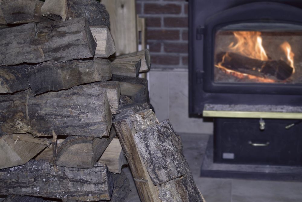 A pile of firewood beside a woodstove