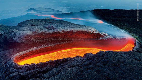 From a great gash on the southern flank of Mount Etna, lava flows within a huge lava tunnel, re-emerging further down the slope as an incandescent red river
