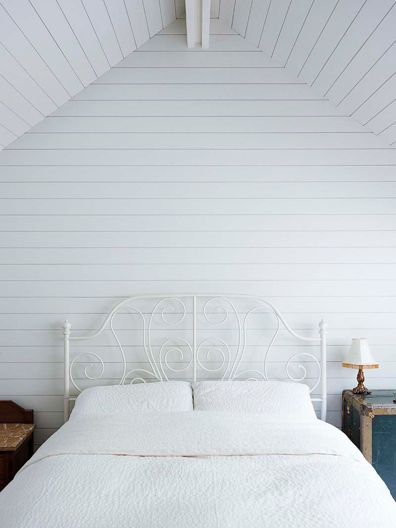 inside of white bedroom with barnboard