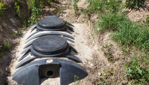 A black septic tank in a sand bed