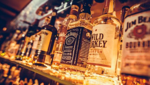 A close-up of a row of alcohol bottles