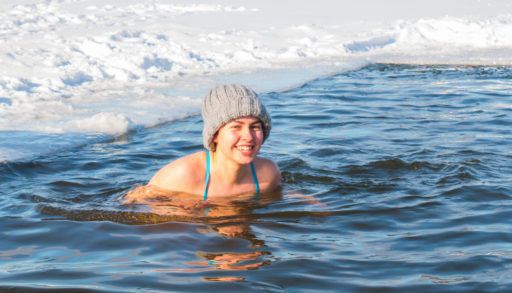 girl swimming in the lake in the winter freezing temperatures