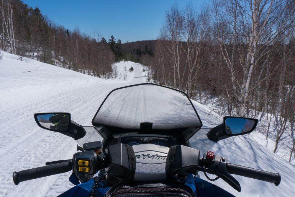 View from the Front Seat of a Snowmobile, looking forward through and over the windshield, to the trail ahead in North Bay, Ontario.