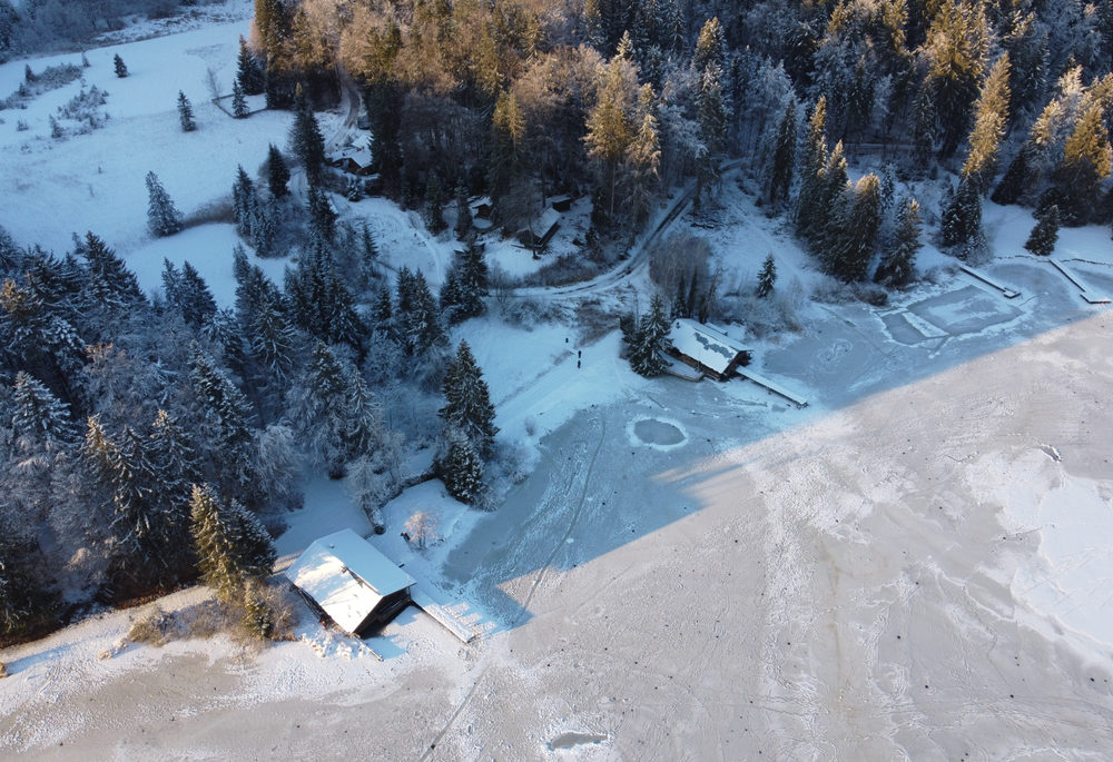 An aerial shot of a frozen lake with docks and boathouses