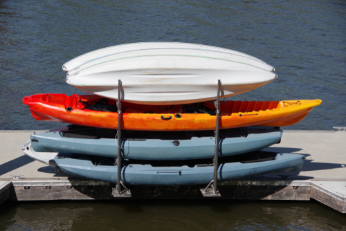 A rack with kayaks on a floating dock on a river