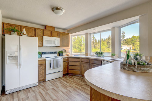 Kitchen interior with older cabinets in American classic lake front rambler house, building materials