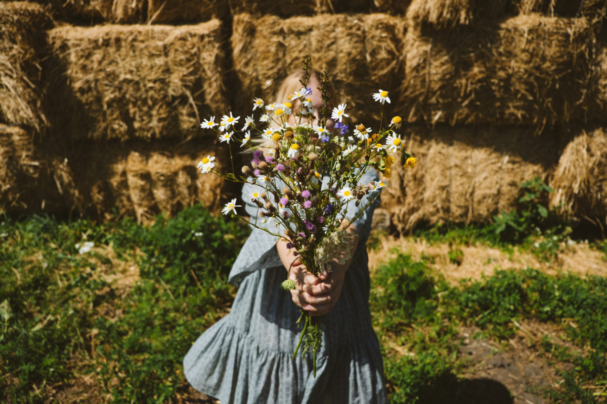 cottagecore girl holds wildflowers in country