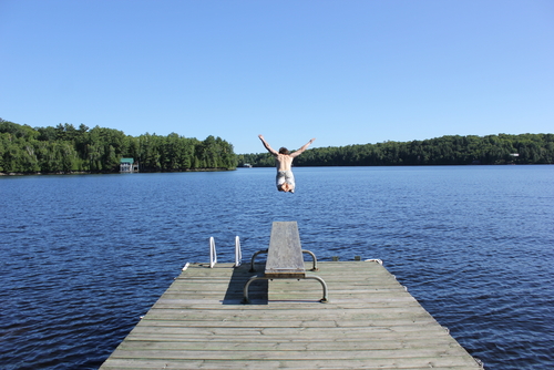 Man Jumping Off a Dock into a lake