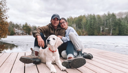 man and woman sitting on a cottage dock with their golden retriever at Crystal Lake