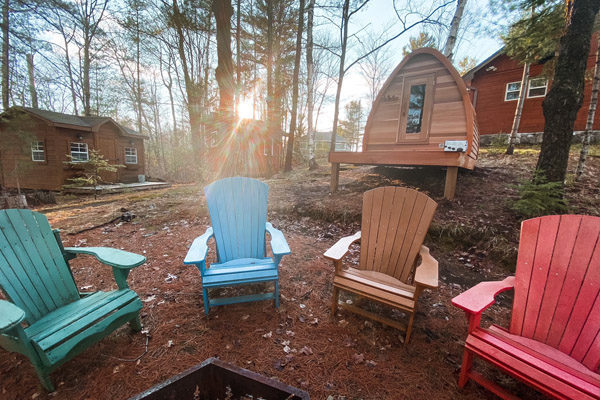 Muskoka chairs around a fire at Crystal Lake