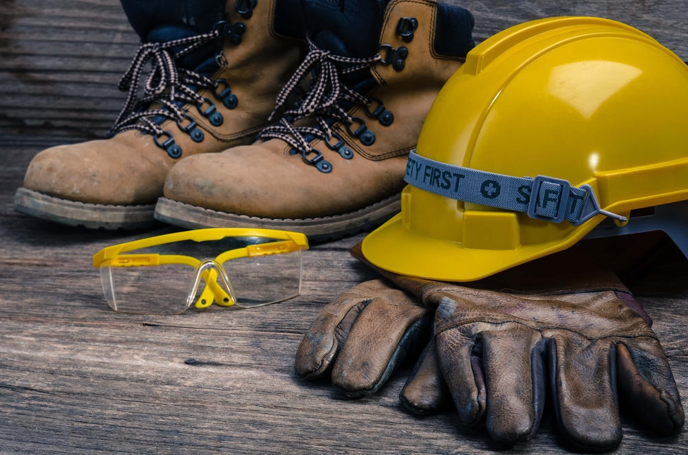 Close-up shot of safety boots, goggles, gloves, and a hard hat.