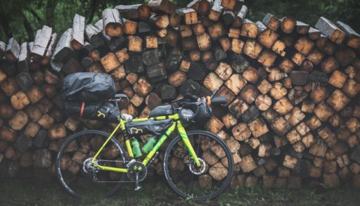 bikepacking bike by woodpile