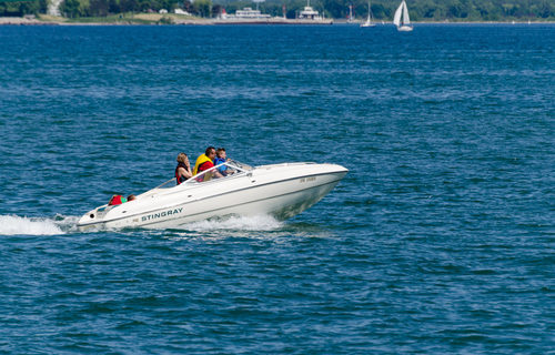 TORONTO, ONTARIO - JUNE 15, 2014: Family in a fast power boat cruising on Lake Ontario along the shoreline, deal-breakers