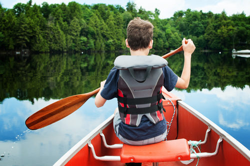 child in the front of a canoe paddling on a calm Canadian lake, deal-breakers