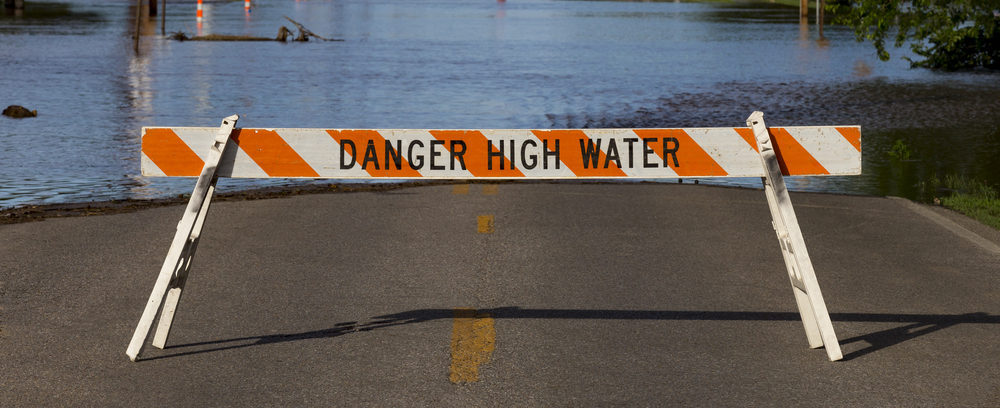 Danger High Water sign in front of flooded road, electrical