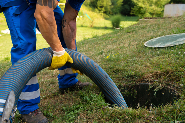 A person emptying a household septic tank.