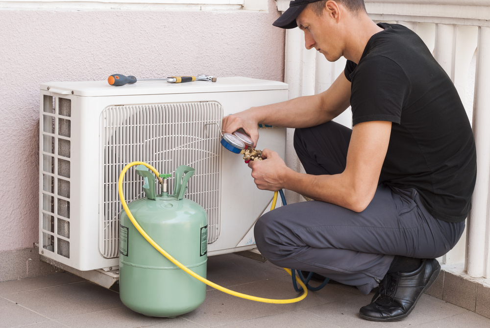 A man repairing an air conditioner.